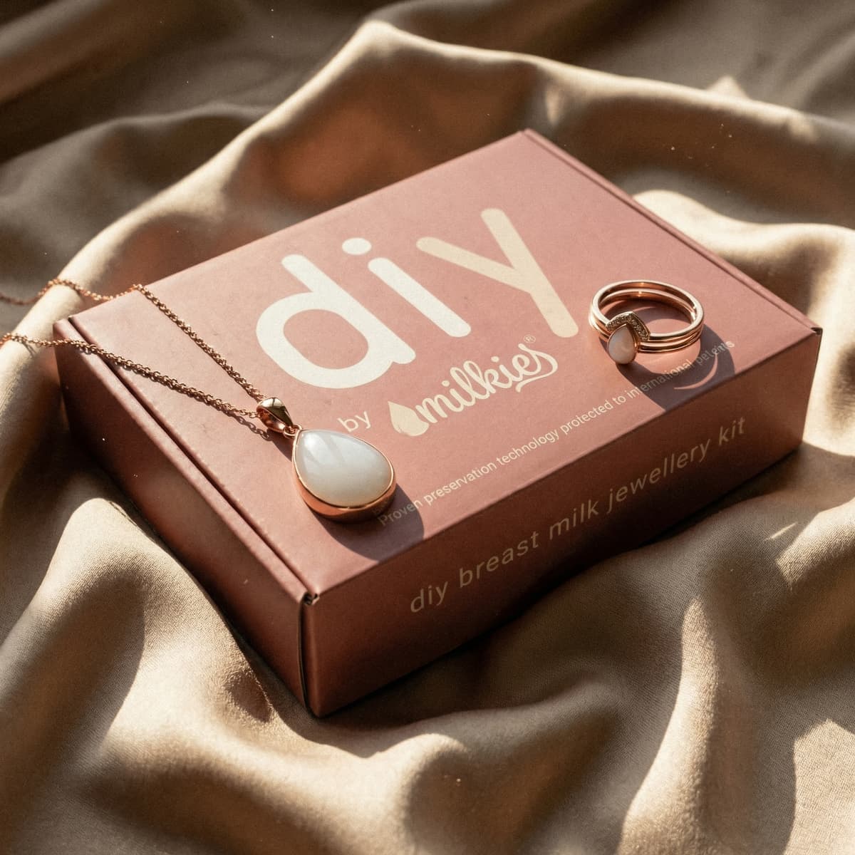DIY by MILKIES Breastmilk-Schmuckset in roséfarbener Box auf weichem Stoff, rosegoldener Tropfen-Anhänger und passender Ring als elegantes geschenk für neue mutter