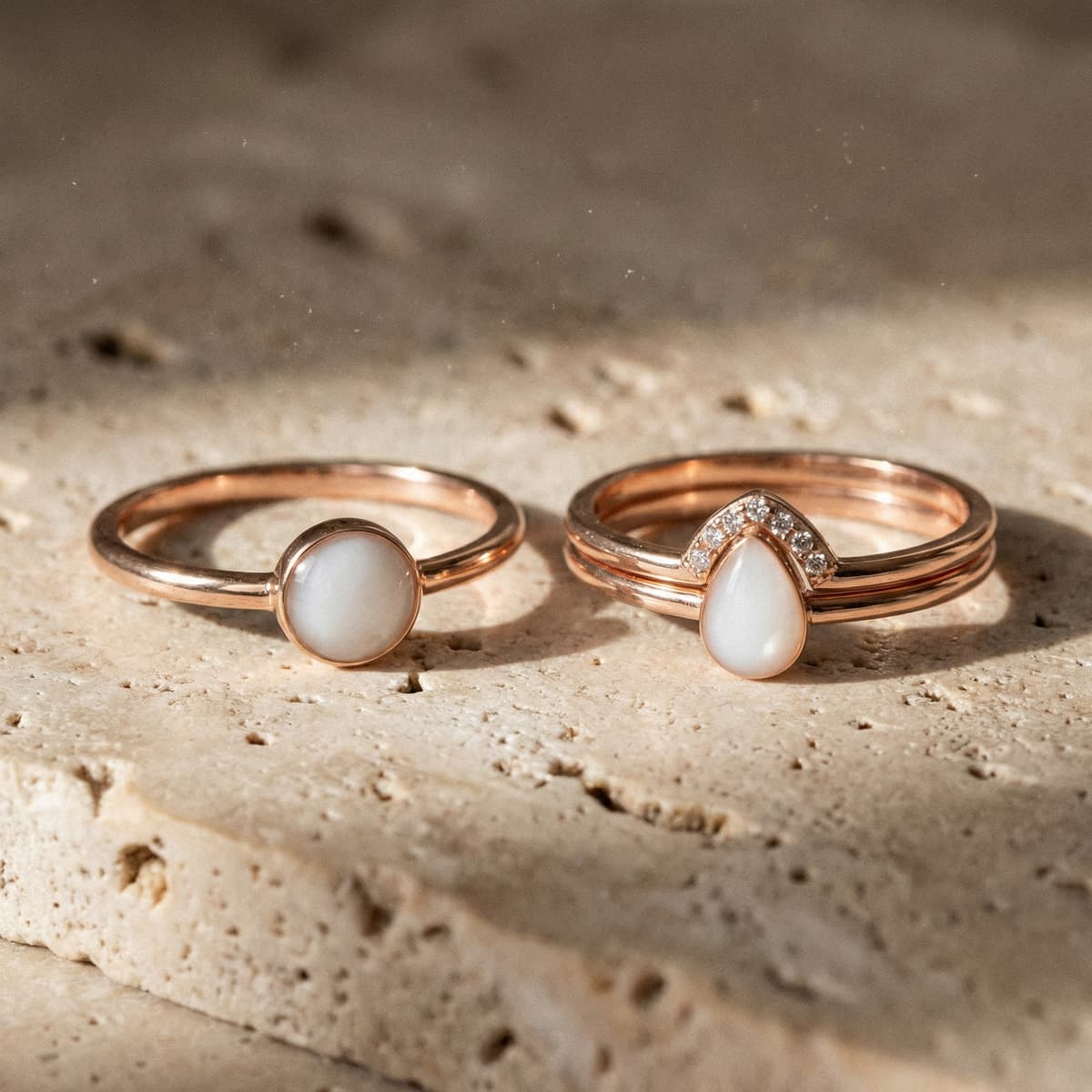 Zwei roségoldene Ringe mit milchig-weißen Steinen auf hellem Naturstein, eleganter muttermilch schmuck ring als persönliches Erinnerungsstück